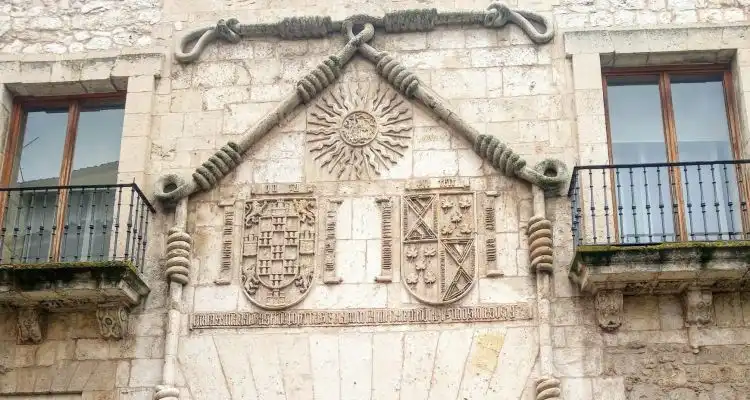 Detalle de la fachada principal de la Casa del Cordón con el cordón franciscano sobre la portada y los escudos de armas
