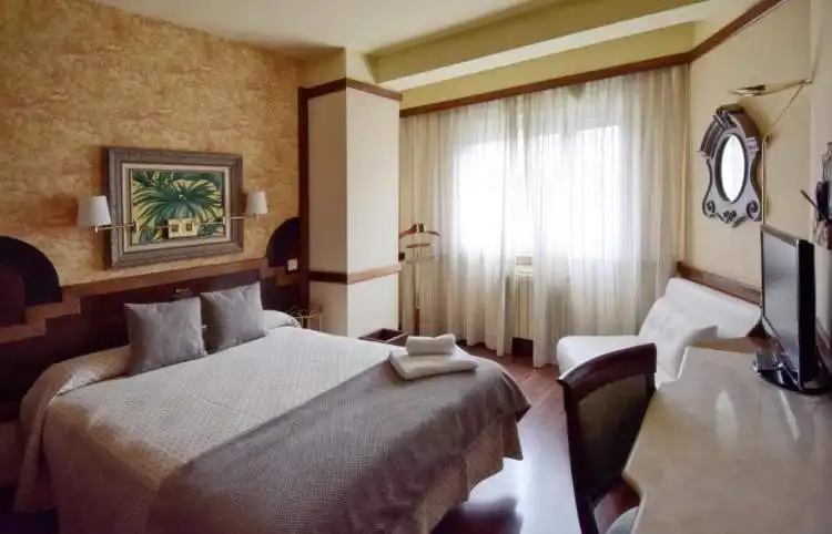 Habitación del Hotel María Luisa con muebles de madera y suelo de parquet